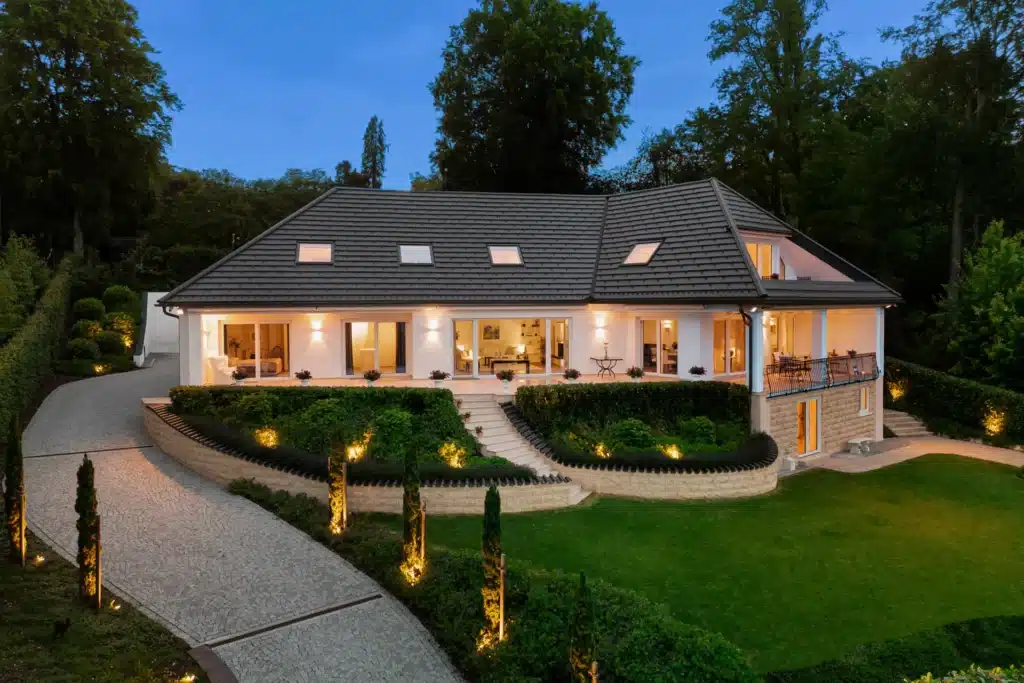 Beleuchtete Landhausvilla am Abend mit Garten – Immobilienfotografie Augsburg