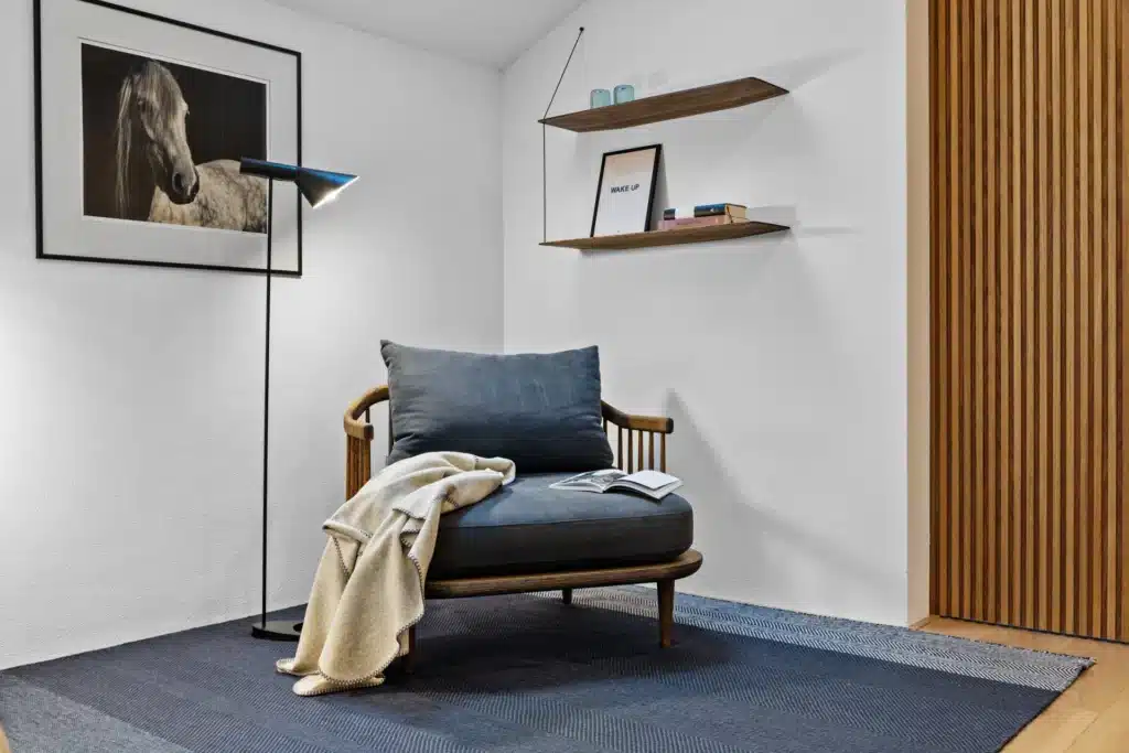 Leseecke mit Sessel und Holzlamellenwand – Immobilienfotografie Ammersee