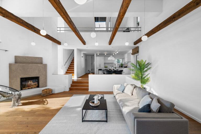 immobilienmarketing-wohnzimmer-doppelhoehe-holzbalken-kamin-starnberg-immoonpoint | ImmoOnPoint